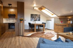 a living room with a table and a kitchen at Ferienwohnung Allgäu-Hilaria in Fischen