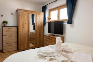 a bedroom with a tv and a bed with white towels at Ferienwohnung Allgäu-Hilaria in Fischen +5 photos
