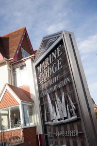 ein Schild vor einem Haus mit Booten im Fenster in der Unterkunft Marine Lodge in Great Yarmouth