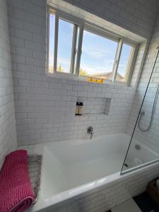 ein weißes Badezimmer mit Badewanne und Fenster in der Unterkunft Green Door Country Home Ein Zivan in Ein Zivan + 77 Fotos