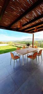 a wooden table and chairs on a patio at Samiro Private Villa - Heated Pool & Hot tub in Áyios Míron +37 photos
