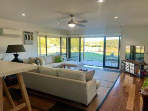 a living room with a couch and a ceiling fan at Perfect weekend getaway plus golf at your doorstep in Salamander Bay