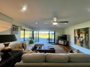 a living room with a couch and a ceiling fan at Perfect weekend getaway plus golf at your doorstep in Salamander Bay