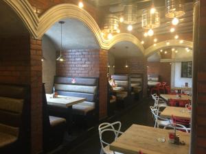 a restaurant with tables and chairs and a brick wall at Picanha Grill Guest House & Events Venue in Nigel
