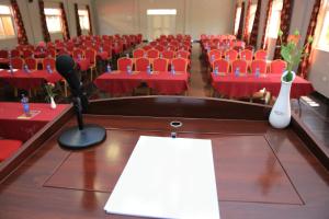 una sala de conferencias con mesas y sillas rojas y un micrófono en Haile Resort Ziway Batu, en Ziway