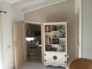 een kamer met een boekenplank met boeken bij Appartamento mansardato Anda&Torra in Castelsardo