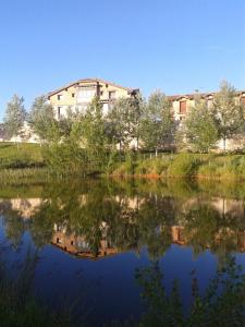 ein im Wasser eines Sees reflektiertes Gebäude in der Unterkunft El Casón de los Poemas in Grajera + 22 Fotos