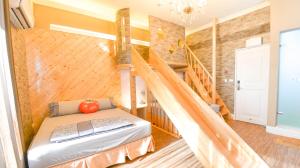 a room with a bed and a staircase at Minsuku B&B in Taitung City