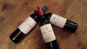 drei Flaschen Wein auf einem Holztisch in der Unterkunft El Casón de los Poemas in Grajera