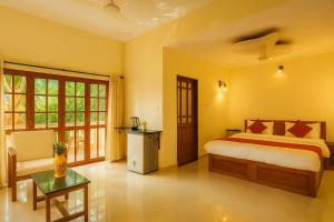 a bedroom with a bed and a chair and a table at Sonikas Leisure in Candolim +51 photos