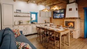 a kitchen and dining room with a table and a fireplace at Heritage Guesthouse in Bartoştana
