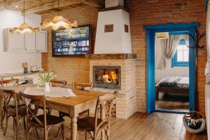 a kitchen and dining room with a table and a fireplace at Heritage Guesthouse in Bartoştana