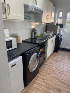 a kitchen with a washer and dryer in it at Tranquil Thamesmead Treasure - Free Parking Family & Contractor Friendly in Thamesmead +34 photos