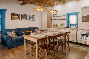 a dining room with a table and a blue couch at Heritage Guesthouse in Bartoştana
