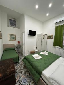 a bedroom with two beds with green sheets at B&B Flora in Piazza Armerina