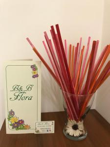a vase filled with colored pencils next to a box at B&B Flora in Piazza Armerina