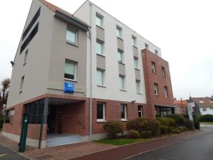 un bâtiment au coin d'une rue dans l'établissement ibis budget Saint-Omer Centre, à Saint-Omer