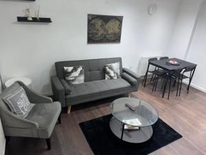 a living room with a couch and a chair and a table at Tranquil Thamesmead Treasure - Free Parking Family & Contractor Friendly in Thamesmead