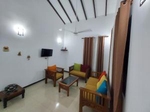 a living room with colorful chairs and a tv at Rugee R Villa in Negombo