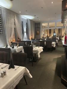 a dining room with white tables and chairs at Hotel Schwarzes Ross Siebenlehn in Siebenlehn