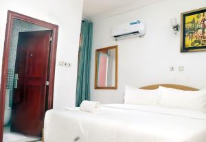 a bedroom with two beds and a red door at Aotel Hotel Lagos Owodunni in Ikeja +33 photos