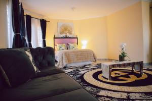 a living room with a couch and a bed at L a Grande deluxe in Benoni