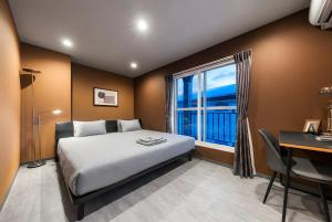 a bedroom with a bed and a desk and a window at The Elements in Nakafurano