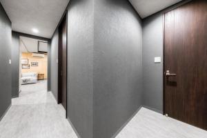 a hallway with gray walls and a wooden door at The Elements in Nakafurano