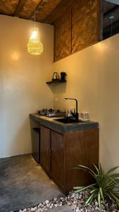 a kitchen with a sink and a stove at Ginhawa Stay Private Pool Studio in Burgos