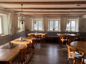a restaurant with wooden tables and chairs and windows at Pension zur Post in Waal