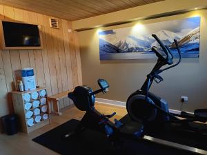 a room with a gym with a treadmill and a tv at Silverstone Lodge in National Park