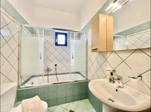 a bathroom with a sink and a tub at Elysian Seaside Villa in Almyrida +12 photos