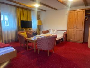 a hotel room with a bed and a table at Pension zur Post in Waal