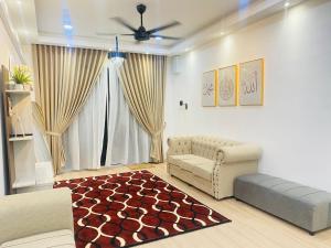 a living room with a couch and a rug at HomestayBondaFaiiha in Port Dickson