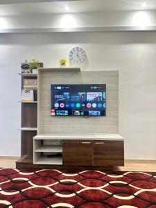 a living room with a flat screen tv on a wall at HomestayBondaFaiiha in Port Dickson +10 photos