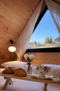 a bed with a table with bread and flowers on it at Tasia's Cottage in Tsalka
