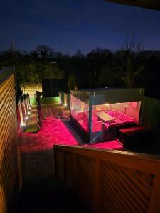 a lit up deck with benches and pink lights at Holiday house Aria Vučedol in Vukovar +4 photos