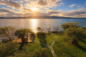 a view of a body of water with the sun setting at Villa Melani in Mytilene