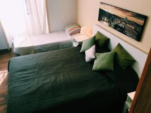 ローマにある4 You City Center Apartamentのベッドルーム1室(緑の枕が付くベッド1台付)