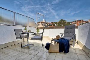 a balcony with a table and chairs on a roof at Bonanova Suite in Barcelona