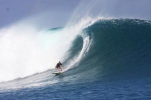 a man riding a wave on a surfboard in the ocean at Villa Sedeoen in Nembrala