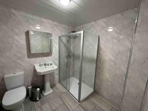 a bathroom with a shower and a toilet and a sink at Arbourfield Lodge in Derby +42 photos