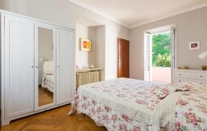 a white bedroom with a bed and a mirror at Rio Molino 1 in Stresa