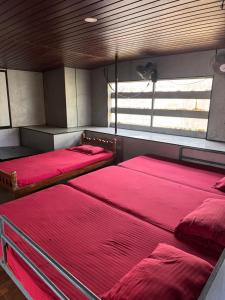 three beds in a room with a window at devanjana Guruvayur in Jāmb