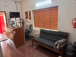 a living room with a couch and a window at devanjana Guruvayur in Jāmb
