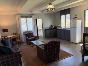 a kitchen and living room with a refrigerator and chairs at Shabach Farm in Hartebeest Rivier