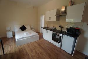 a small kitchen with a white couch in a room at Arbourfield Lodge in Derby