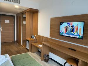 a hotel room with a television on a wall at BUSINESS EXPRESS HOTEL in Kapaklı