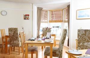 a dining room with a wooden table and chairs at The Beach House in Weymouth