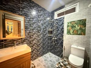 a bathroom with a toilet and a sink and a shower at Sufficient House in Nong Prue